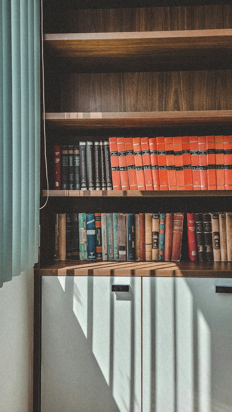Libreria in legno piena di libri di riferimento legali.